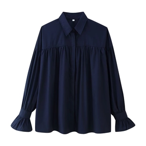 Detail of navy blue blouse showing pleated front design and elegant ruffled trumpet sleeves