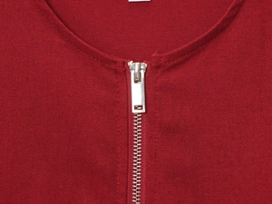 Detail of red linen fabric texture and silver metal zipper on crew neck jacket top