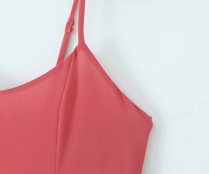 Detail of pink slip dress showing adjustable thin straps and silver metal buckles