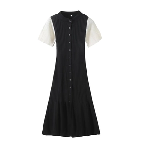 Close-up of black ribbed knit dress featuring white bubble sleeves and button details