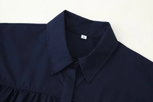 Close-up of the lapel collar and buttons on this navy blue flared sleeve shirt