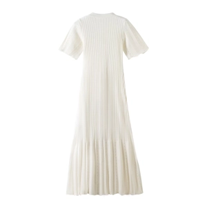 Close-up of the delicate hollow-out pattern on the hem of a white knitted dress