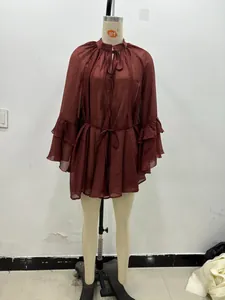 Detail of burgundy chiffon dress featuring ruffled bell sleeves and tie neck collar