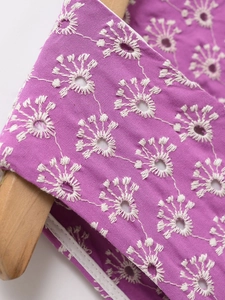 Makro-Detail der lila Bluse mit weißer Blumenstickerei und feiner Lochstickerei