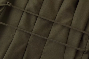 Detail view of olive green fabric with vertical pleats and parallel drawstring design