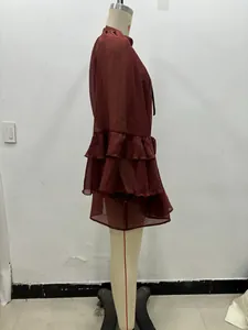 Detail of burgundy dress featuring triple-layered ruffle cuffs and soft pleated fabric