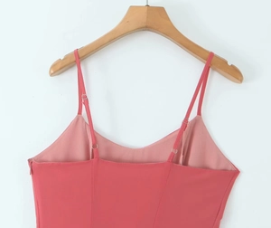 Detail of adjustable straps and side zipper on a slim fit peach vacation dress