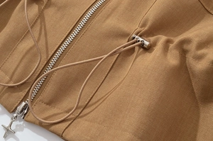 Macro view of khaki twill jacket featuring silver metal zipper and star detail