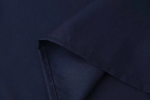 Detailed close-up of dark blue fabric texture and fine stitching on the lapel shirt