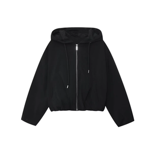 Détail d'une veste noire à capuche zippée avec cordon de serrage et ourlet élastique