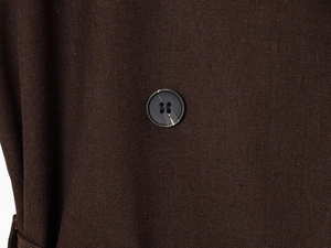Detailed macro view of chocolate brown fabric texture and marble pattern button detail