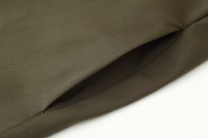 Detail view of the hidden side pocket and durable army green fabric on the V-neck dress
