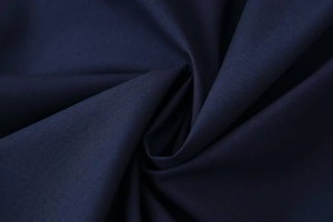 Detailed macro view of deep blue woven fabric texture with elegant drapes and smooth finish