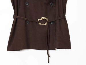 Close-up of espresso brown double-breasted top with textured fabric and gold buckle