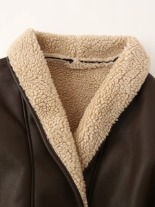 Detailed view of dark brown leather jacket collar with thick beige faux shearling lining