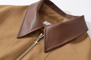 Close-up of khaki jacket with faux leather collar and star-shaped metal zipper detail