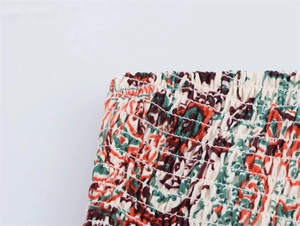 Détail du tissu smocké élastique avec imprimé floral vintage et coutures de précision