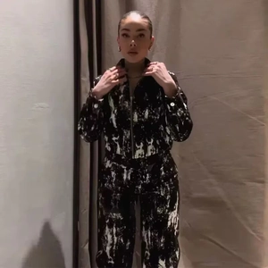 Dettaglio della fantasia a macchie d'inchiostro nero e bianco su giacca e pantaloni casual
