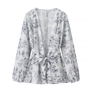 Detailed close-up of blue floral print wrap top with waist tie and V-neckline