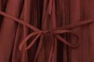 Close-up of plisse textured fabric detail and matching waist tie on summer dress