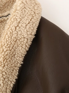Detail shot of premium dark brown faux leather and soft cream faux fur jacket lining