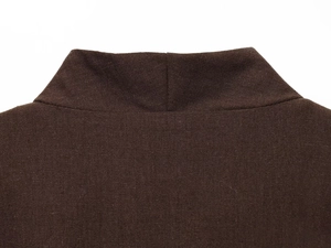 Detail view of the high-neckline and woven fabric texture on a dark brown elegant top