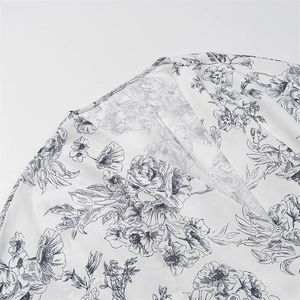 Detail shot of black floral print on white breathable fabric with V-neckline texture