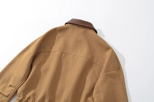 Detail view of khaki cotton twill jacket with brown leather patchwork collar