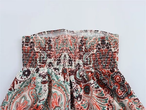 Détails de broderie smocking à motif paisley rouge et vert sur cette robe cintrée