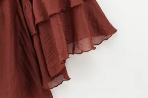 Detail of burgundy ruffled sleeve with layered textured fabric and fine stitching