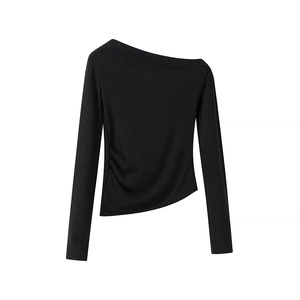 Detail of asymmetrical off-shoulder black knit top with side pleats and irregular hemline