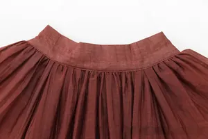 Macro detail of dark brown pleated organza fabric with precise accordion pleats
