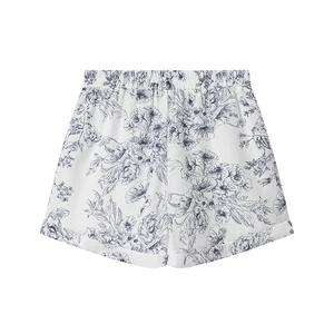 Detailed view of high-waisted white shorts with blue floral print and elastic waist