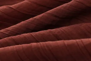 Macro view of dark red chiffon fabric texture with fine vertical pleated patterns