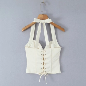 Detail of white halter corset top with back bow tie and front lace-up closure