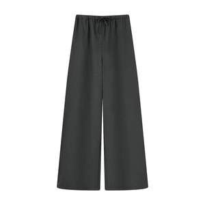 Detail of black wide-leg trousers featuring an elastic drawstring waist and textured fabric