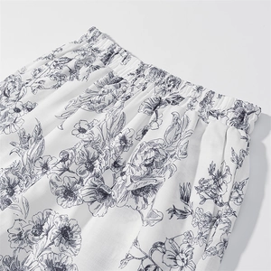 Detail of high-waist elastic waistband on summer shorts with black floral line art