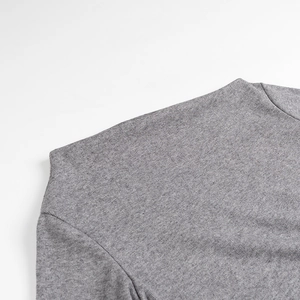 Close-up of grey fine knit texture and shoulder stitching on a long-sleeved sweater