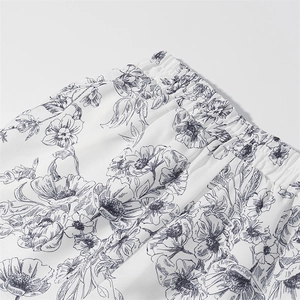Detail of white shorts with black floral print and elastic waistband texture