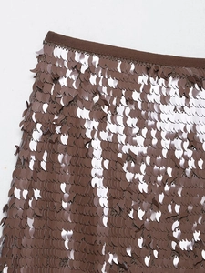 Dettaglio di minigonna con paillettes marroni che mostra le paillettes a foglia