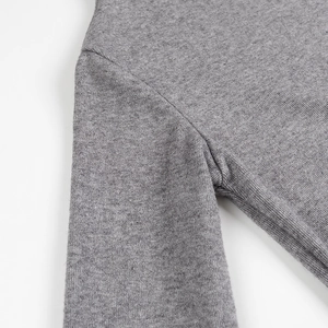 Detailed macro view showing professional stitching on grey knit shoulder seam and fabric texture