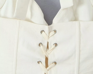 Detailed view of the corset top featuring lace-up straps with silver metal eyelets