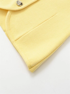 Detailed macro view of yellow knit sweater fabric and irregular silver metal button