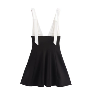 Detail of white V-neck bodice with bow shoulder straps and black A-line skirt