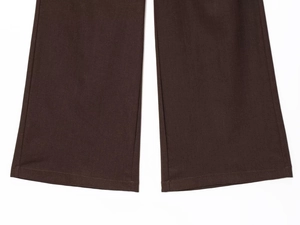 Close-up of brown wide-leg trousers featuring detailed twill fabric and premium stitching