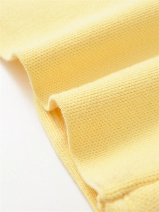 Detailed macro view of the bright yellow knit fabric texture and soft cotton blend fibers