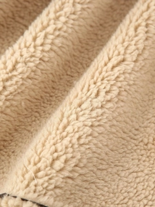 Close-up of soft khaki sherpa fleece fabric showing dense curly texture and warm material