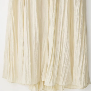 Elegant beige pleated summer maxi dress with premium draped texture and minimalist style