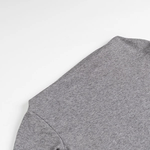 Detail of the light grey fine knit texture and shoulder seam on a chic off-shoulder sweater