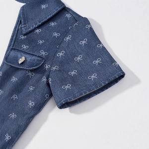 Short sleeve denim dress with white bow embroidery and a rhinestone button detail
